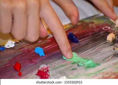 Finger Painting With Oil Paints. A Child Poked Into The Artist's Palette. Art Studio. Child Learn To Draw. Children's Art Therapy.