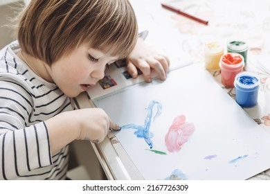 Finger painting. Portrait of cute little boy painting with fingers at home. Close-up of child's hand in colorful paints. Early education concept. Sensory play. Development of fine motor skills. - Powered by Shutterstock