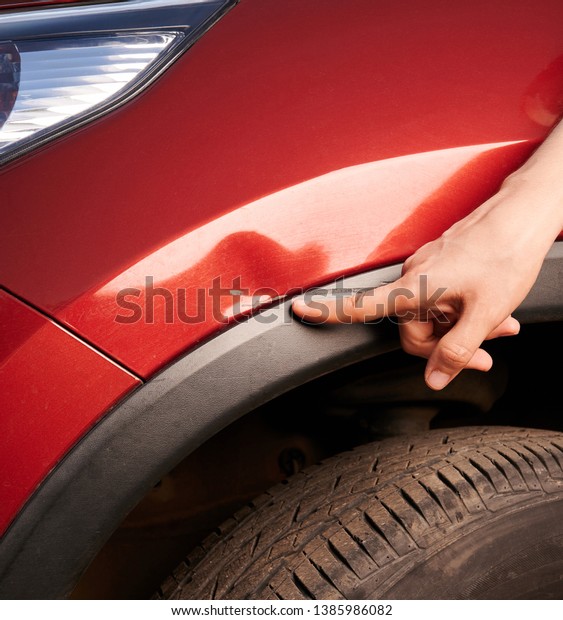 Finger point at car\
scratch near wheel area