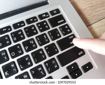 a finger point at enter button on notebook keyboard - Shutterstock ID 1097029553