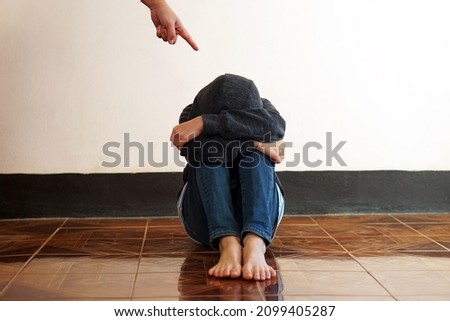 A finger point to a guilty feeling boy sit on the floor. Concept : Intimidation or stick discipline strategy to control or punish kid behavior that affect to mental in childhood. Psychology.