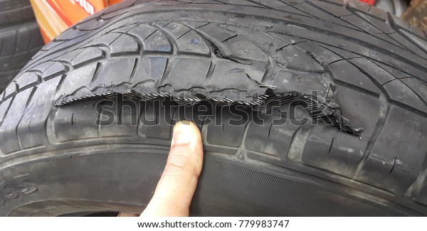 Finger
pointing to blown out tear tire. Soft focus
image