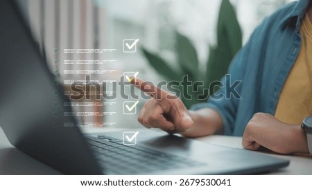 Finger pointing at a digital checklist interface on a laptop screen. Concept of task management, productivity planning, online workflow organization, and digital to-do list system.
