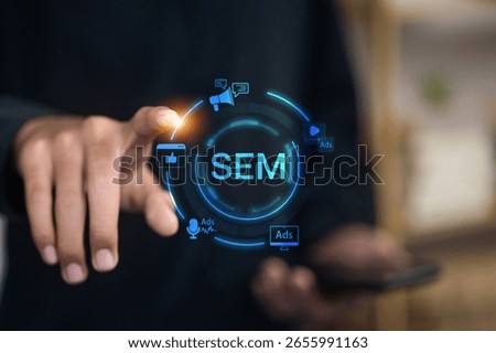 Finger pointing to SEM text surrounded by digital marketing icons such as ads, megaphone, social media, and search on smartphone.
