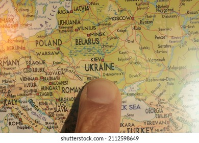 Finger pointing Ukraine on the map. Conflict between Russia and Ukraine - Shutterstock ID 2112598649