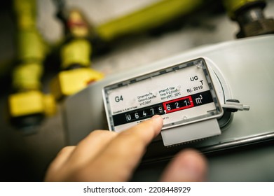 Finger Points To Gas Meter With Meter Reading In The Basement