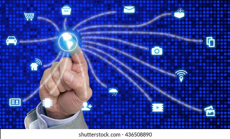 Finger presses glowing globe connecting internet of things icons with digital datastreams on blue dotted background
