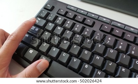 Finger pressing alt-tab command on the keyboard.