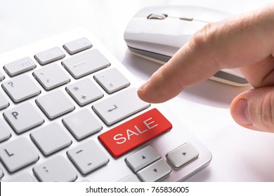 Finger pressing computer button with red sale sign