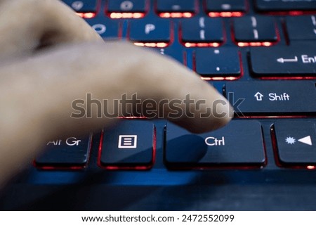 Finger pressing the ctrl key of the laptop