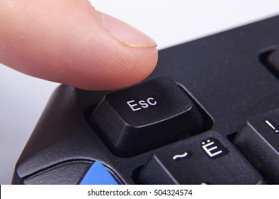 Finger pressing Esc button on computer keyboard