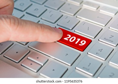 finger pressing keyboard key written 2019 newyear. finger presses a button on the gray keyboard. Beginning of new year - Shutterstock ID 1195635376