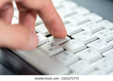 Finger Pressing One Single Key On A White Laptop Keyboard, Shallow Dof, Object Macro, Detail, Extreme Closeup. Using A Computer, User Experience, Interaction, Data Input Simple Abstract Concept