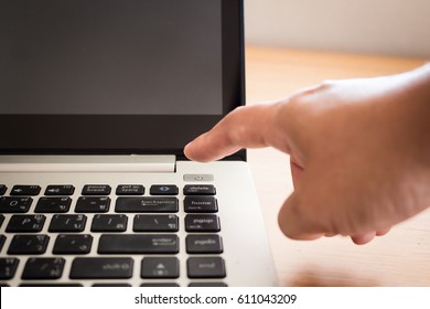 Finger Pressing Power Button On Laptop Keyboard