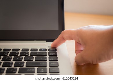 Finger Pressing Power Button On Laptop Keyboard