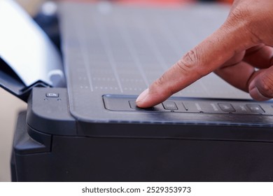 Finger pressing the printer power button