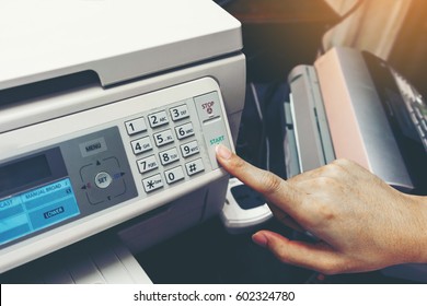 Finger pressing start button of fax machine , office equipment