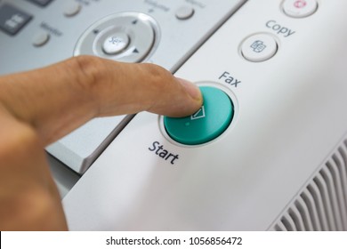Finger pressing start button on the fax, business concept.