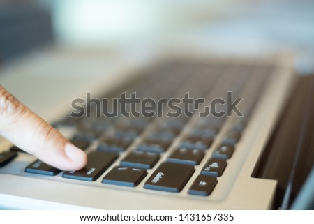 finger push the enter button of notebook keyboard. selective, soft focus