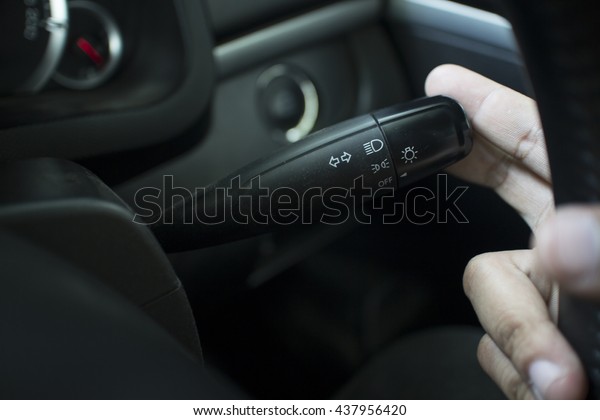 Finger Push a lighting control button on the car\
steering wheel