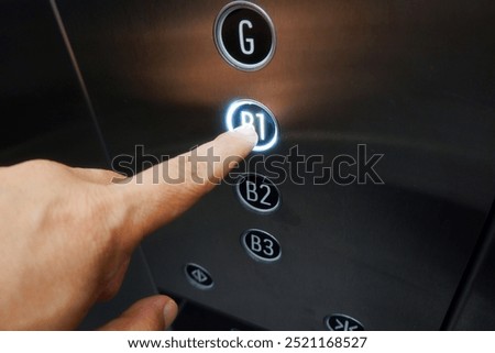 A finger is pushing address push button on elevator or passenger lift.