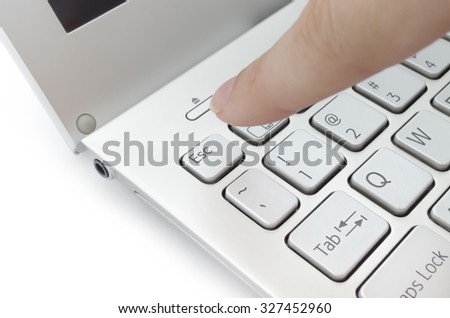 Finger pushing escape button on laptop keyboard; isolated on white background