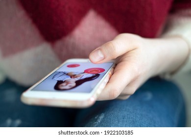 Finger pushing heart icon on screen in smartphone application. Friend, follower or fan liking picture of a beautiful woman.