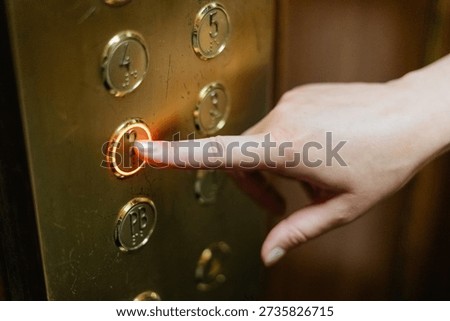 Finger pushing old elevator button