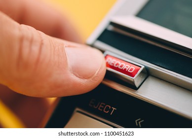 Finger pushing Record button on vintage audio cassette player, close up of retro technology with selective focus