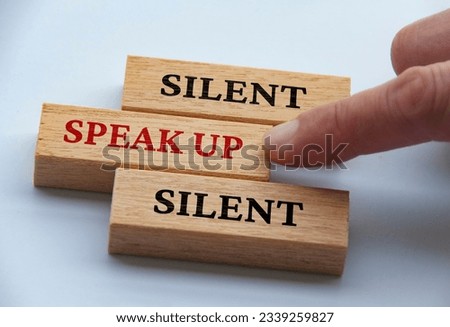 Finger pushing wooden block with red written text speak up. Courage and speak up concept