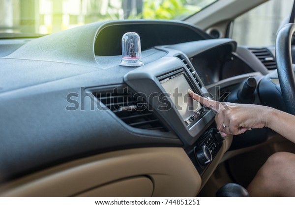 Finger screen and turning on car radio\
system,Button on dashboard in car\
panel