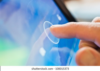 finger touching screen  on tablet-pc with shallow depth of field