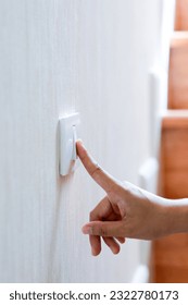 Finger turning off or turning on on lighting switch at home with wooden step background. Power, Energy, Saving Electrical concept, close up. - Shutterstock ID 2322780173