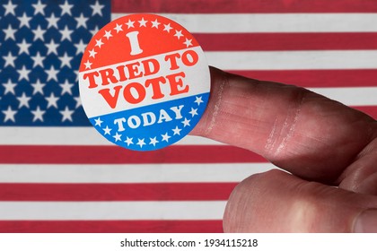 Finger With I Voted Button In Front Of Voting Stickers Given To US Voters. This Illustrates State Laws To Suppress Votes And Make It Difficult To Vote