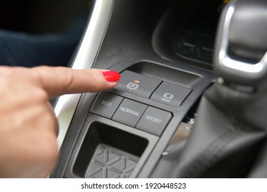 The Finger Of A Woman On The Electric Parking Brake