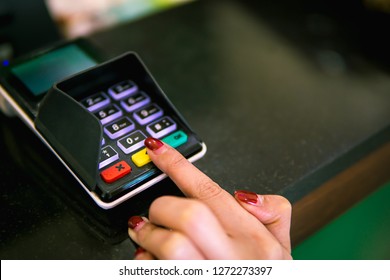 finger of women inserting password or pin code login on machine keypad of payment terminal