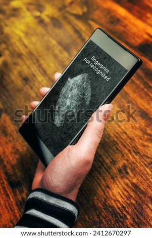 Fingerprint not recognized message on mobile smartphone screen after a sensor scan of female thumb failed to authenticate user and unlock electronics device