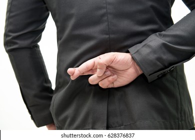 Fingers crossed. Rear view of businessman crossing fingers behind his back while isolated on white, bright picture of man with crossed fingers - Powered by Shutterstock