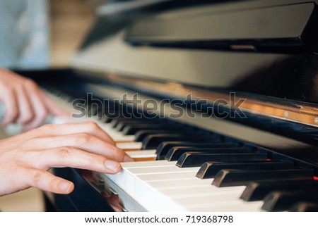 fingers of a man playing piano. pianist pressing keys. black and white piano keyboard background. close piano key side view.
