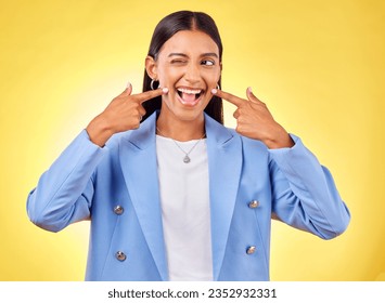 Fingers on cheek, smile and a happy woman in studio for positive attitude, dimples and emoji. Indian model person or student with fashion, comic and funny face or silly mood on a yellow background