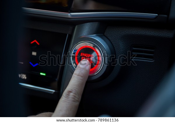 Fingers pressing car start\
button