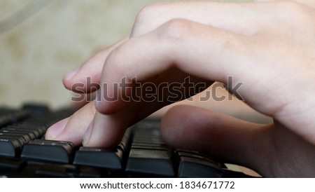 Fingers touch keyboards while playing computer game. Left hand typing on black computer keys closeup