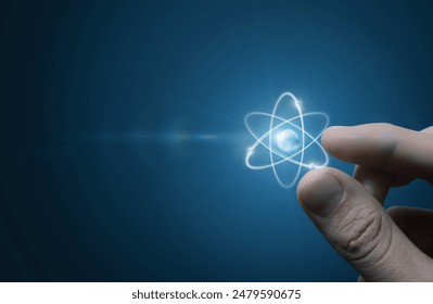 Fingers touching an atom on a blue background. - Powered by Shutterstock