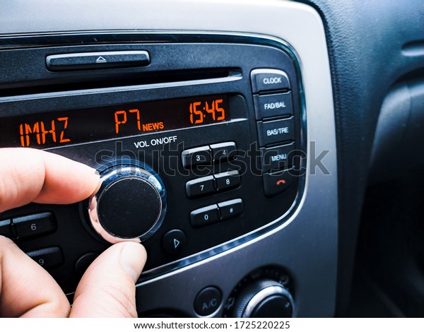 fingers turn the volume\
of the car radio