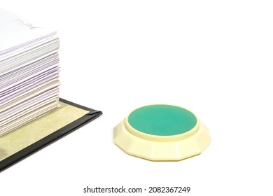 fingertip moistener and stack of papers close up on white background