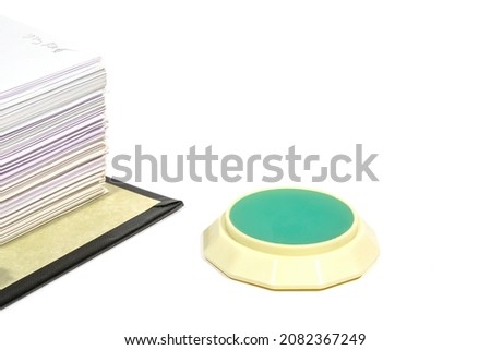 fingertip moistener and stack of papers close up on white background
