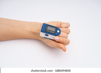 Fingertip Pulse Oximeter On Finger. On White Background. Device For Self Health Diagnostic.