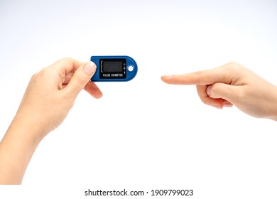 Fingertip Pulse Oximeter On Finger. On White Background. Device For Self Health Diagnostic.