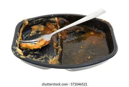 A Finished Barbecue And Potato TV Dinner With A Fork In The Tray Isolated On A White Background.