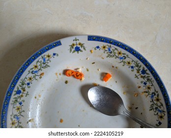 Finished Meal On A Plate. There Are Still Few Sliced Chili And A Metal Spoon On The Plate.